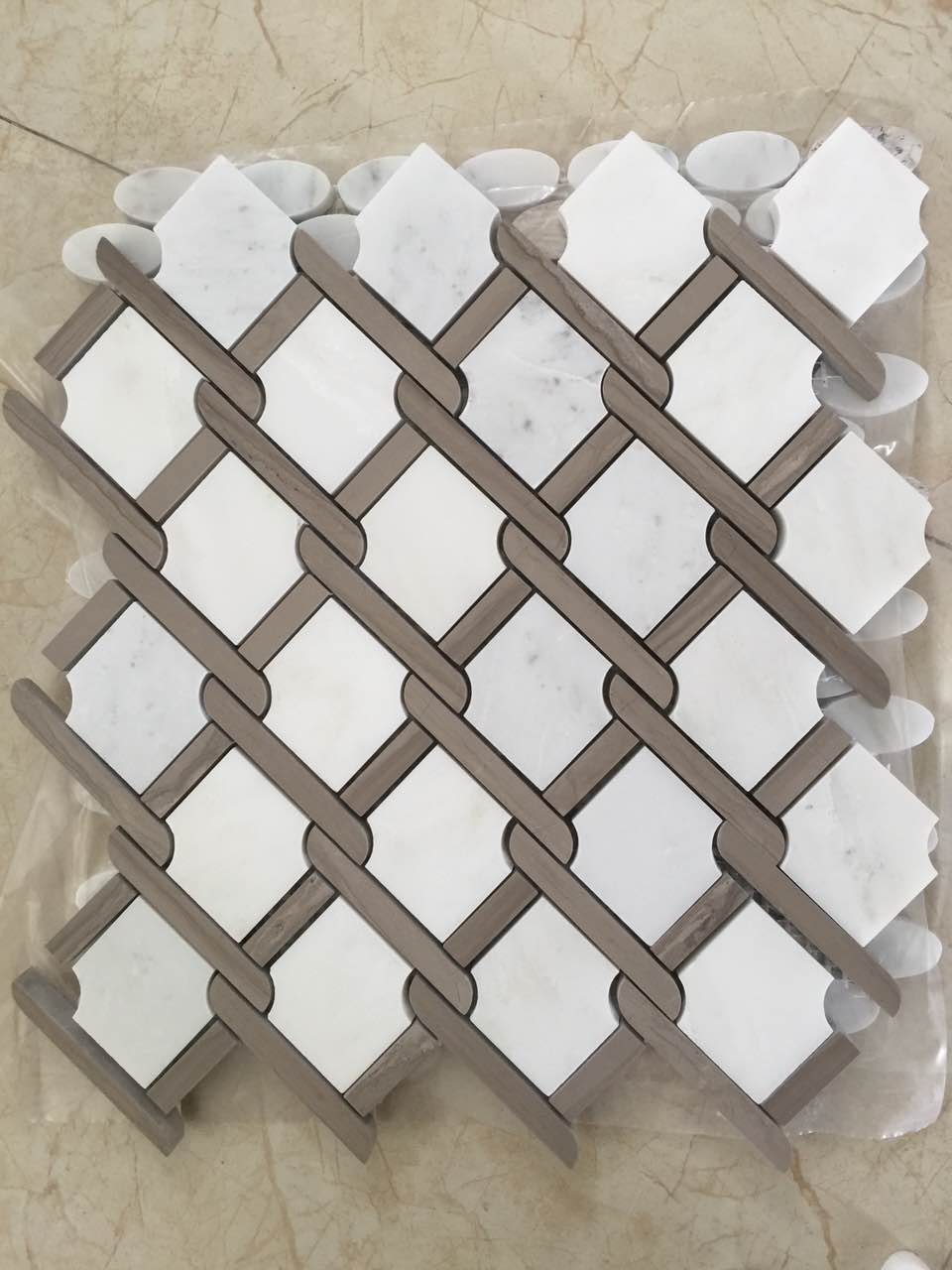Real product photo — complete mesh-mounted sheet of the brown and white lattice natural marble mosaic; natural stone variation and approved sample control final appearance