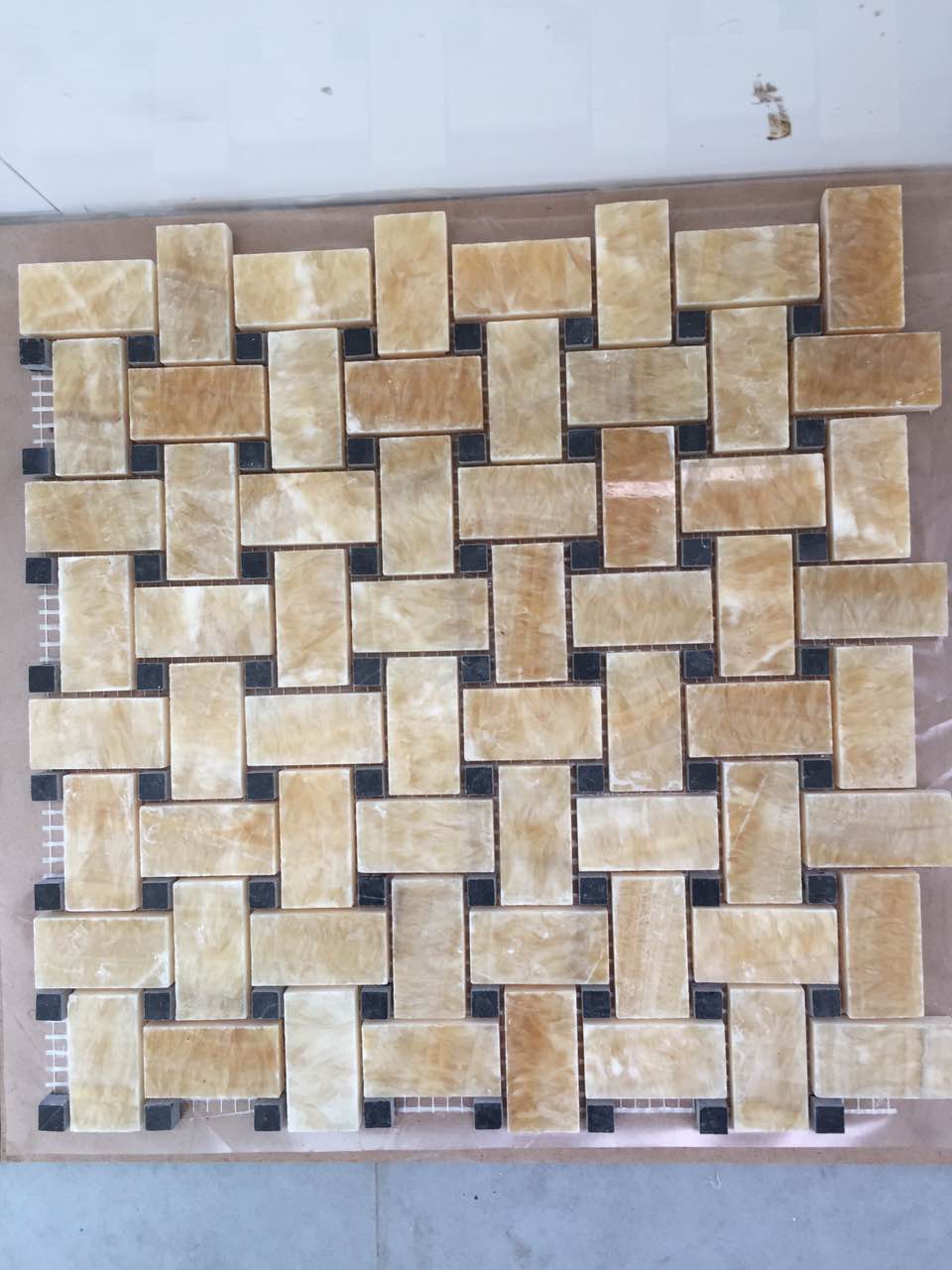 Real product photo — complete mesh-mounted sheet of the golden brown basketweave natural marble mosaic; natural stone variation and approved sample control final appearance