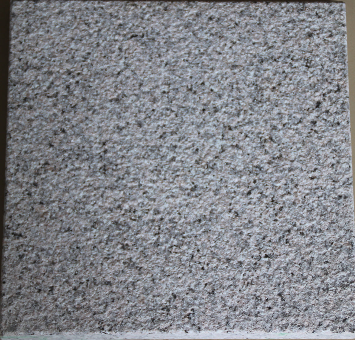 Real product photo — Sakura Red natural granite sample showing the full slab and bush-hammered surface; approved sample controls final colour and texture