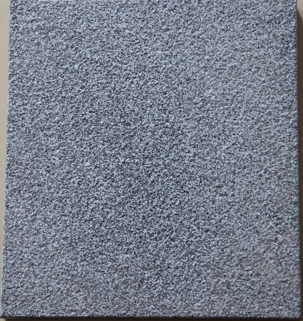 Real product photo — Shanxi Black natural granite sample showing the bush-hammered surface at high resolution; approved sample controls final colour and texture