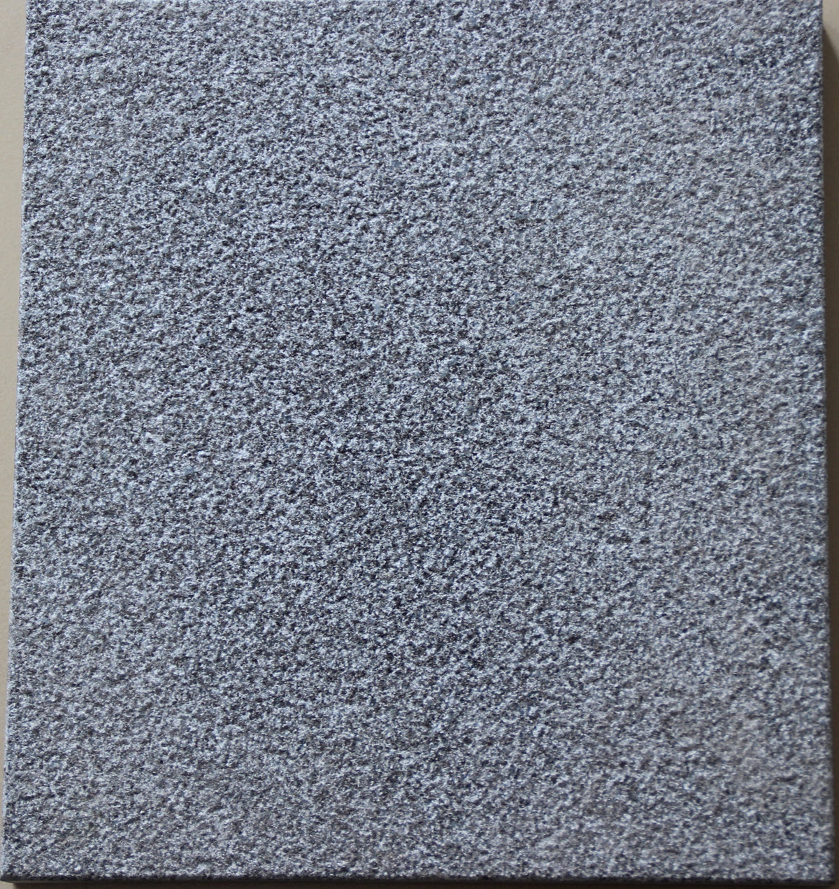 Real product photo — Shanxi Black natural granite sample showing the bush-hammered surface at high resolution; approved sample controls final colour and texture