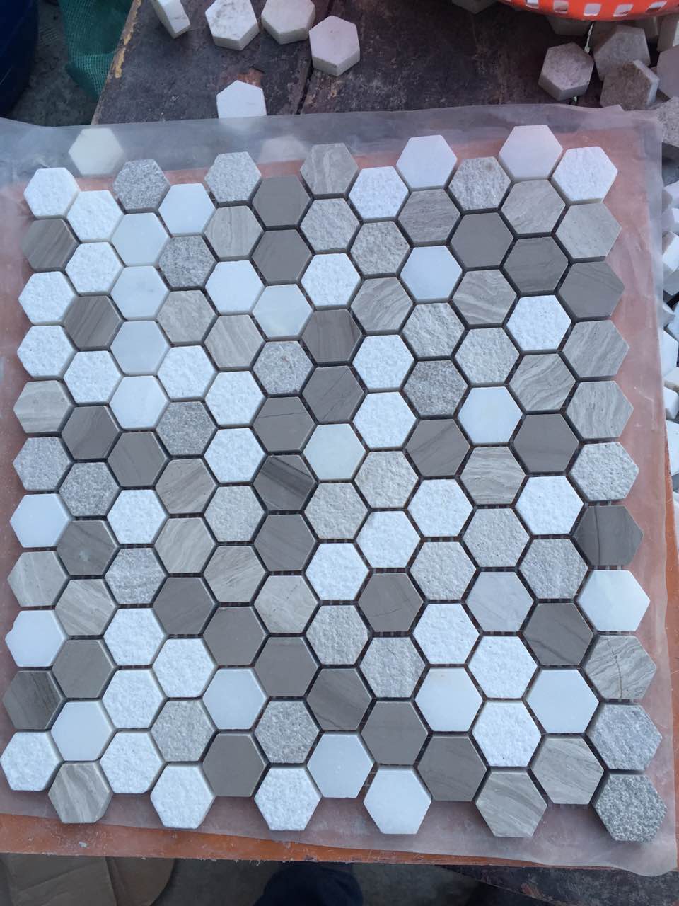 Real product photo — complete mesh-mounted sheet of the white, grey and black hexagon natural marble mosaic; natural stone variation and approved sample control final appearance